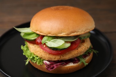 Delicious vegan burger with chickpea cutlet on wooden table, closeup