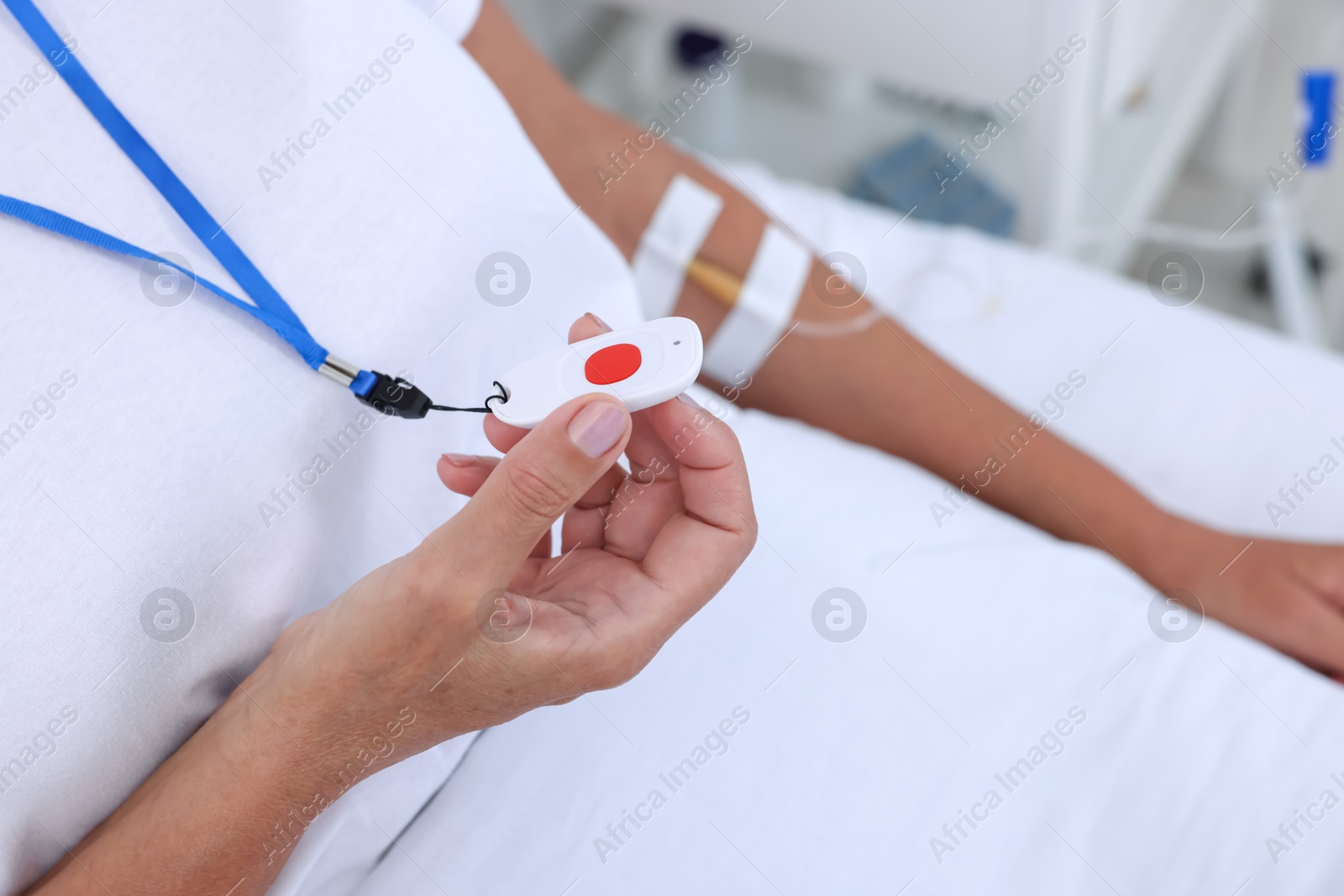 Photo of Senior woman with emergency call button on bed in hospital, closeup