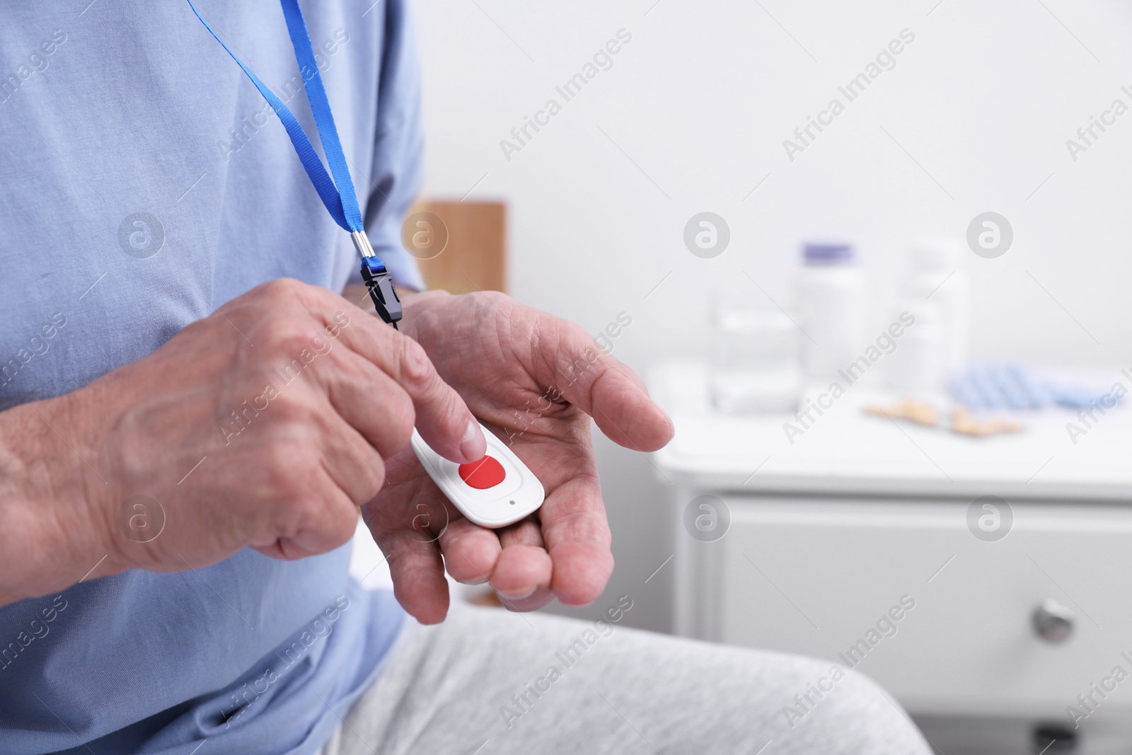 Photo of Senior man pressing emergency call button on bed in hospital, closeup