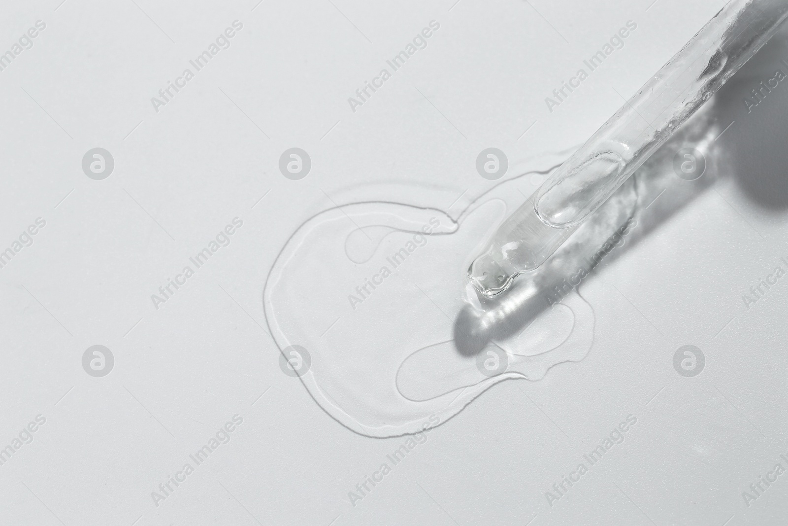 Photo of Cosmetic oil and pipette on light grey background, top view