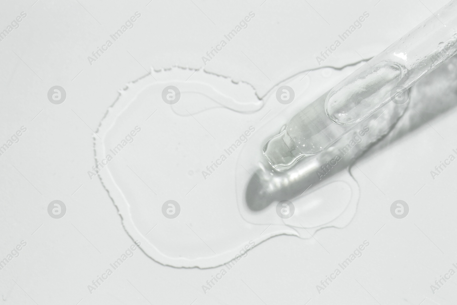 Photo of Cosmetic oil and pipette on light grey background, top view