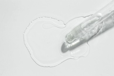 Photo of Cosmetic oil and pipette on light grey background, top view