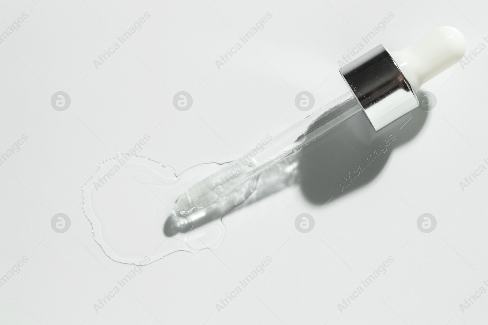 Photo of Cosmetic oil and pipette on light grey background, top view