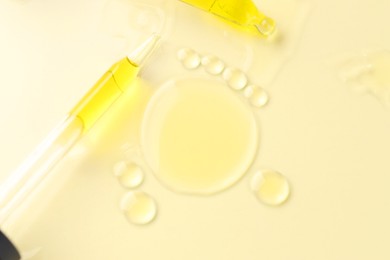 Photo of Cosmetic oil and pipettes on dark beige background, flat lay