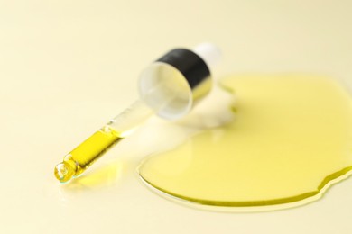 Photo of Cosmetic oil and pipette on dark beige background, closeup