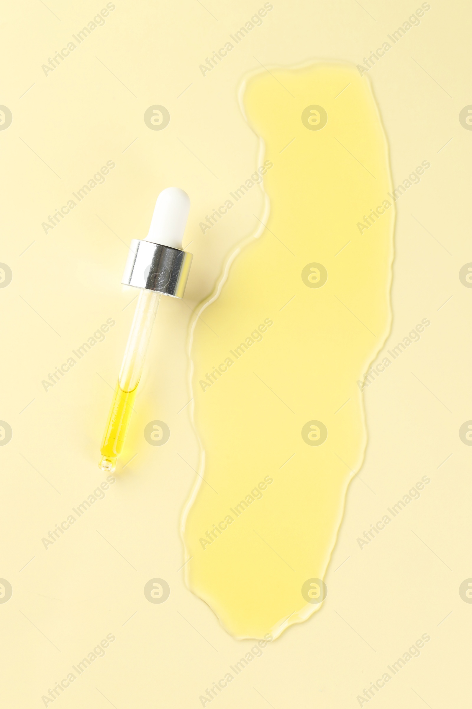 Photo of Cosmetic oil and pipette on dark beige background, top view