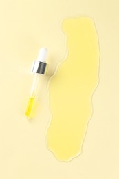 Cosmetic oil and pipette on dark beige background, top view