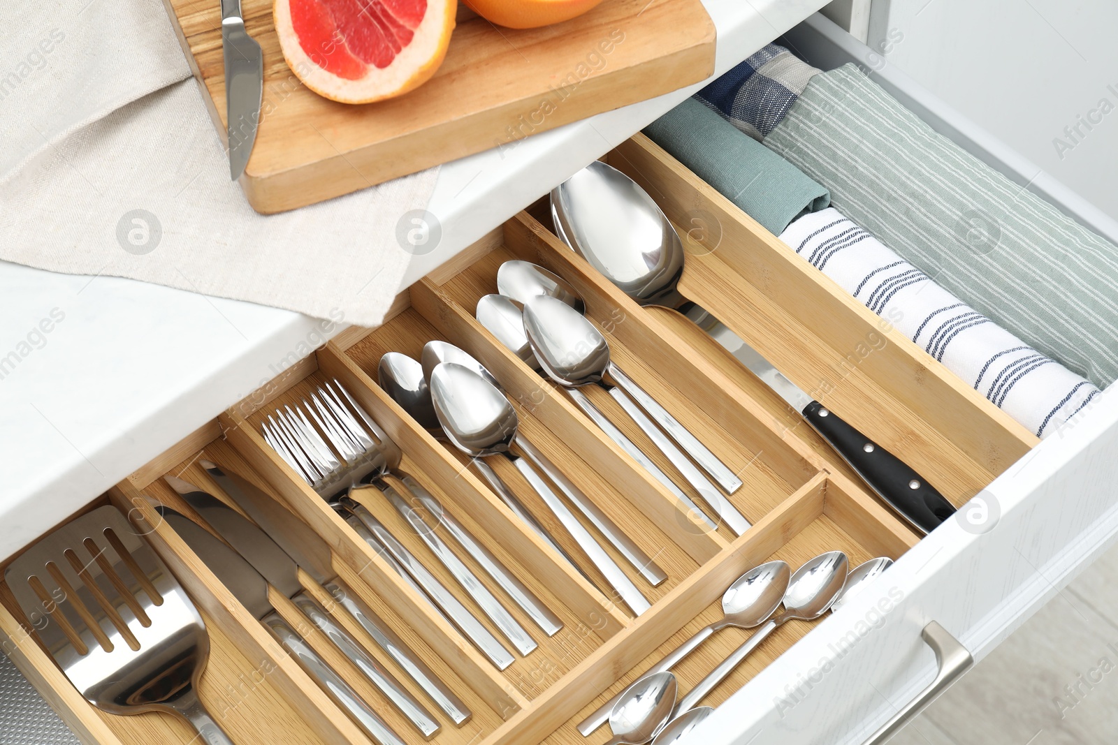 Photo of Box with cutlery in drawer, above view. Kitchen utensils storage