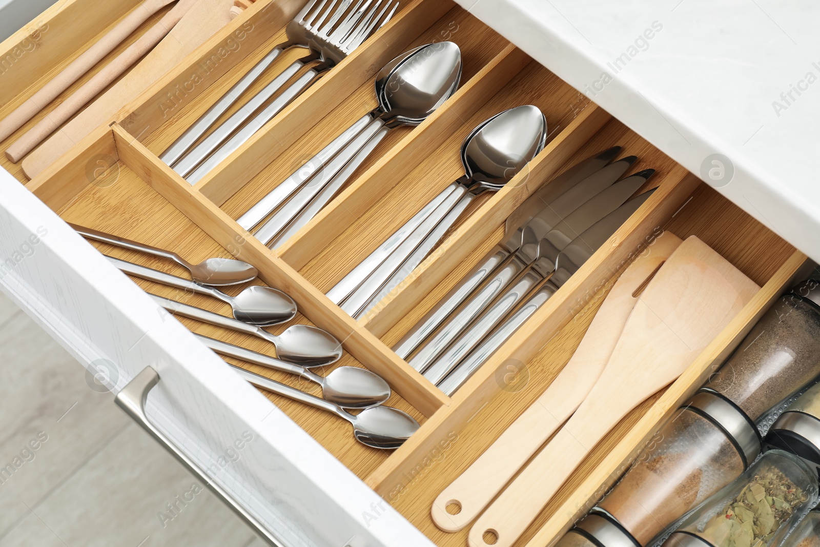 Photo of Box with cutlery in drawer, closeup. Kitchen utensils storage