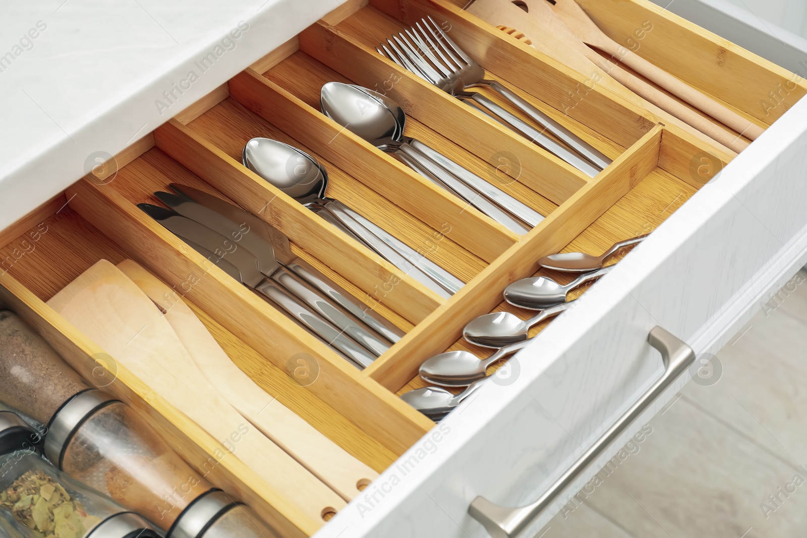 Photo of Box with cutlery in drawer, closeup. Kitchen utensils storage