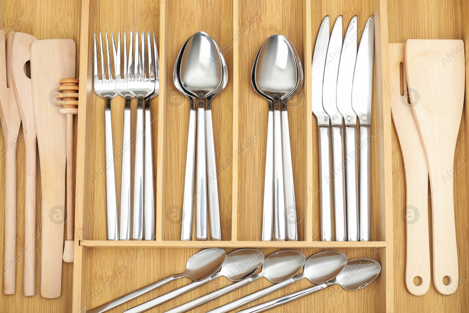 Photo of Cutlery in wooden box, top view. Kitchen utensils storage