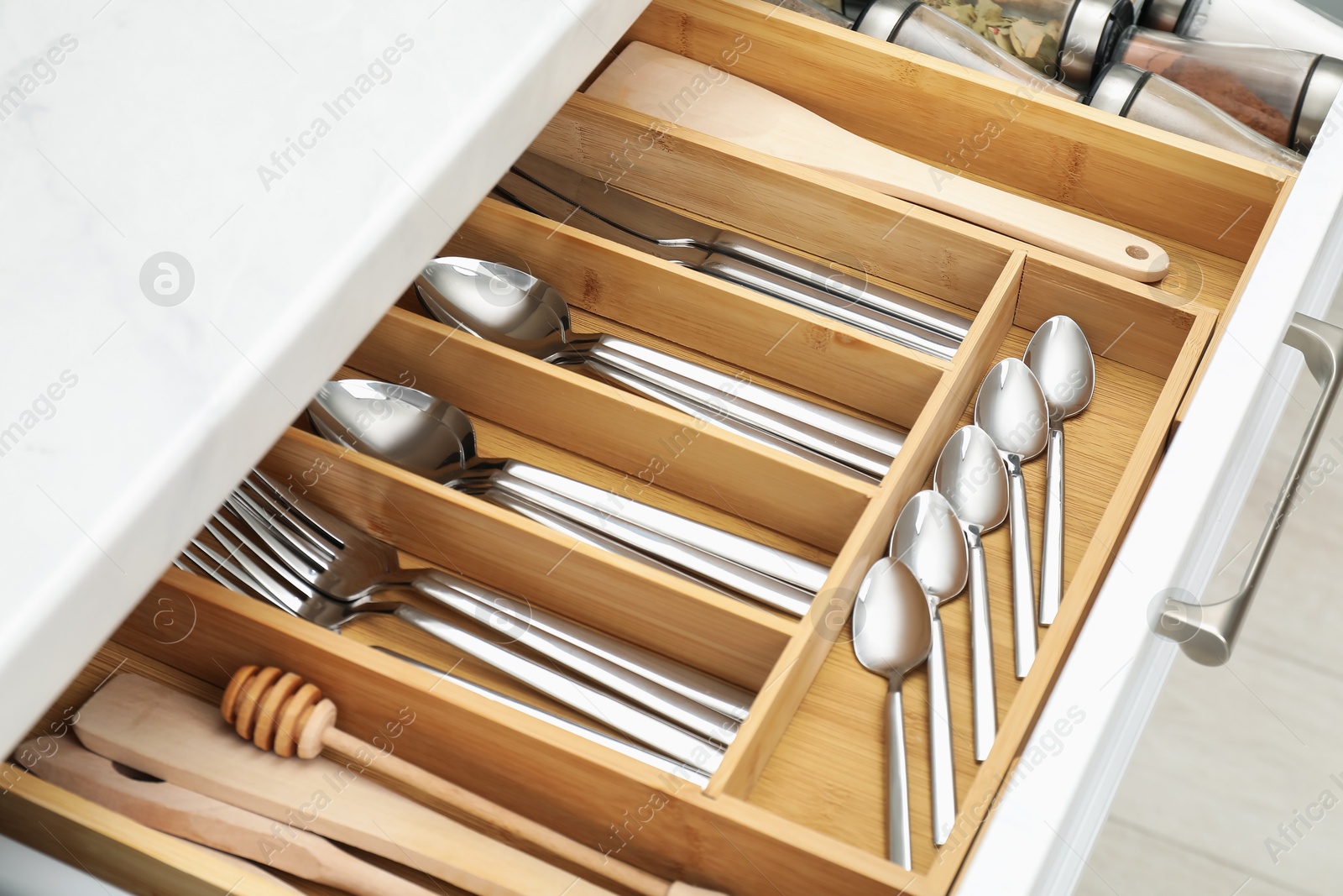 Photo of Box with cutlery in drawer, closeup. Kitchen utensils storage