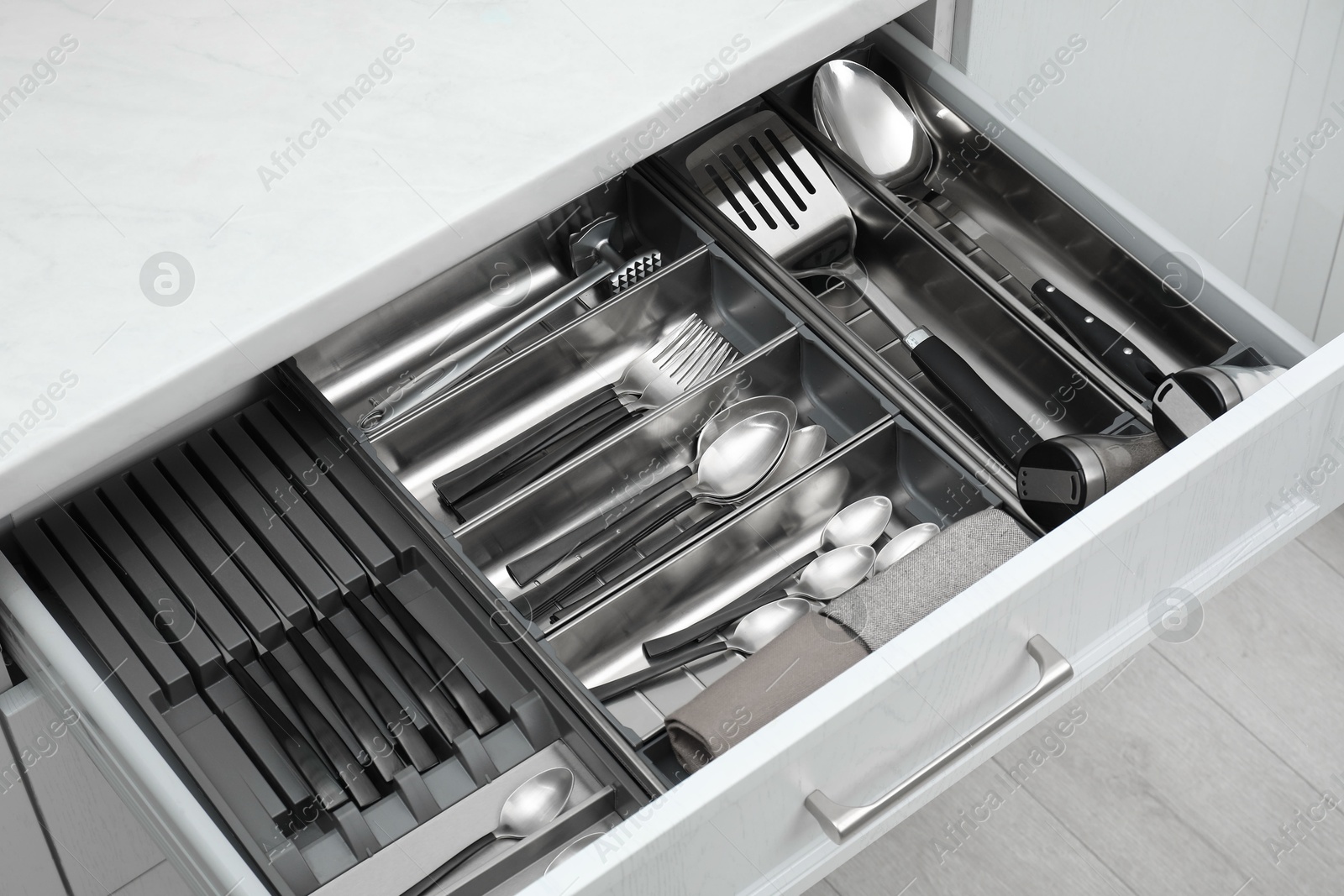 Photo of Box with cutlery in drawer, closeup. Kitchen utensils storage