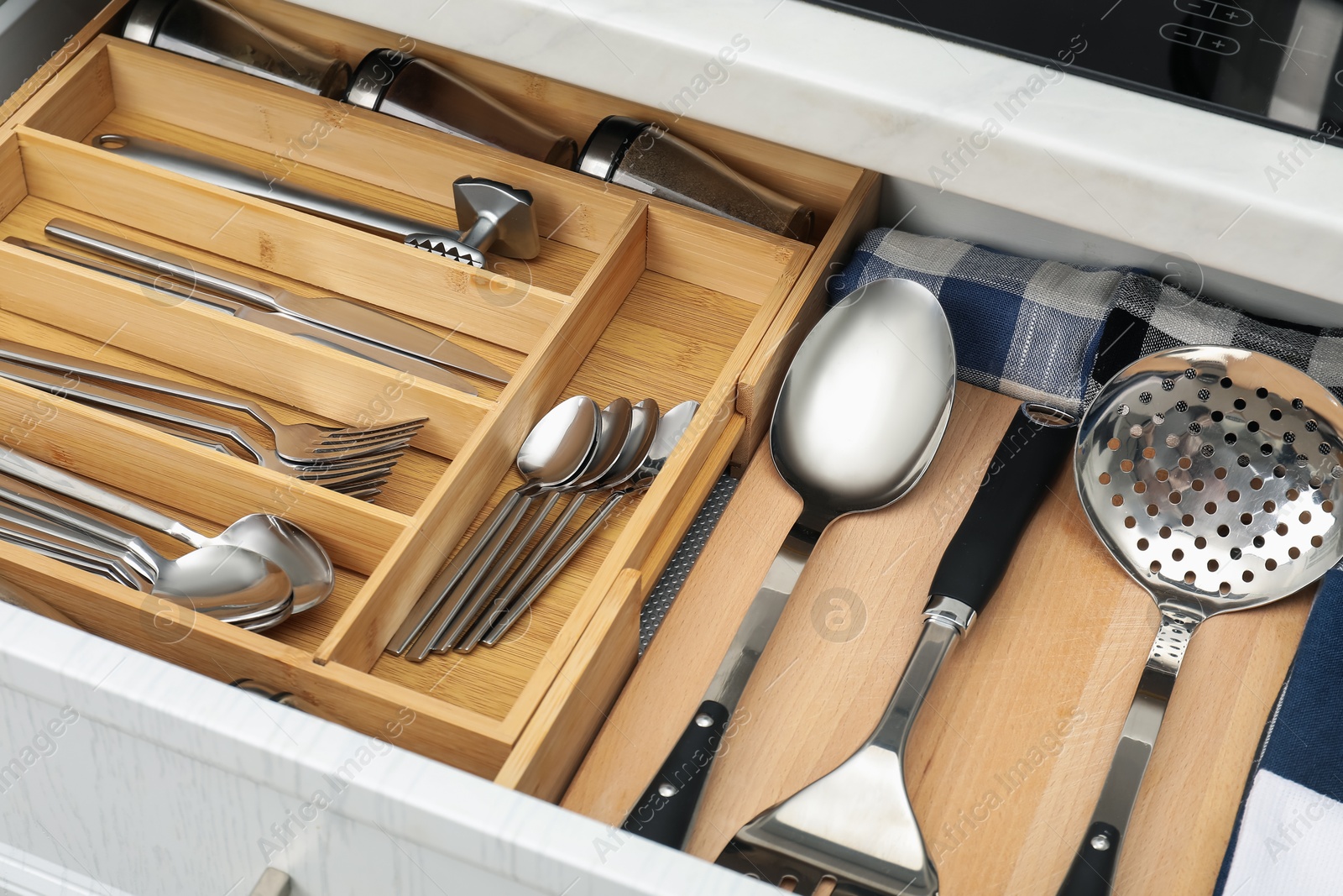 Photo of Box with cutlery in drawer, closeup. Kitchen utensils storage