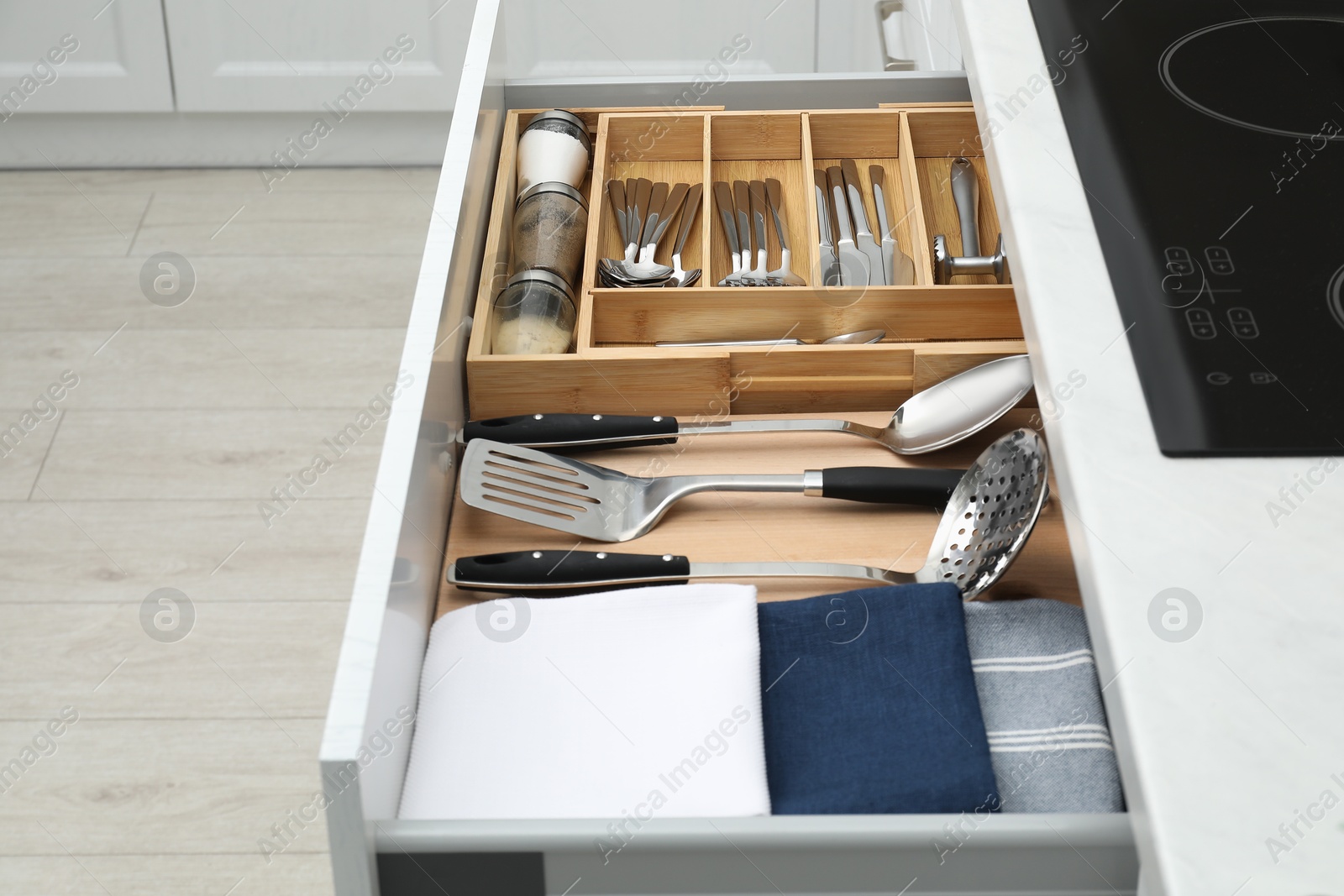 Photo of Box with cutlery in drawer, closeup. Kitchen utensils storage