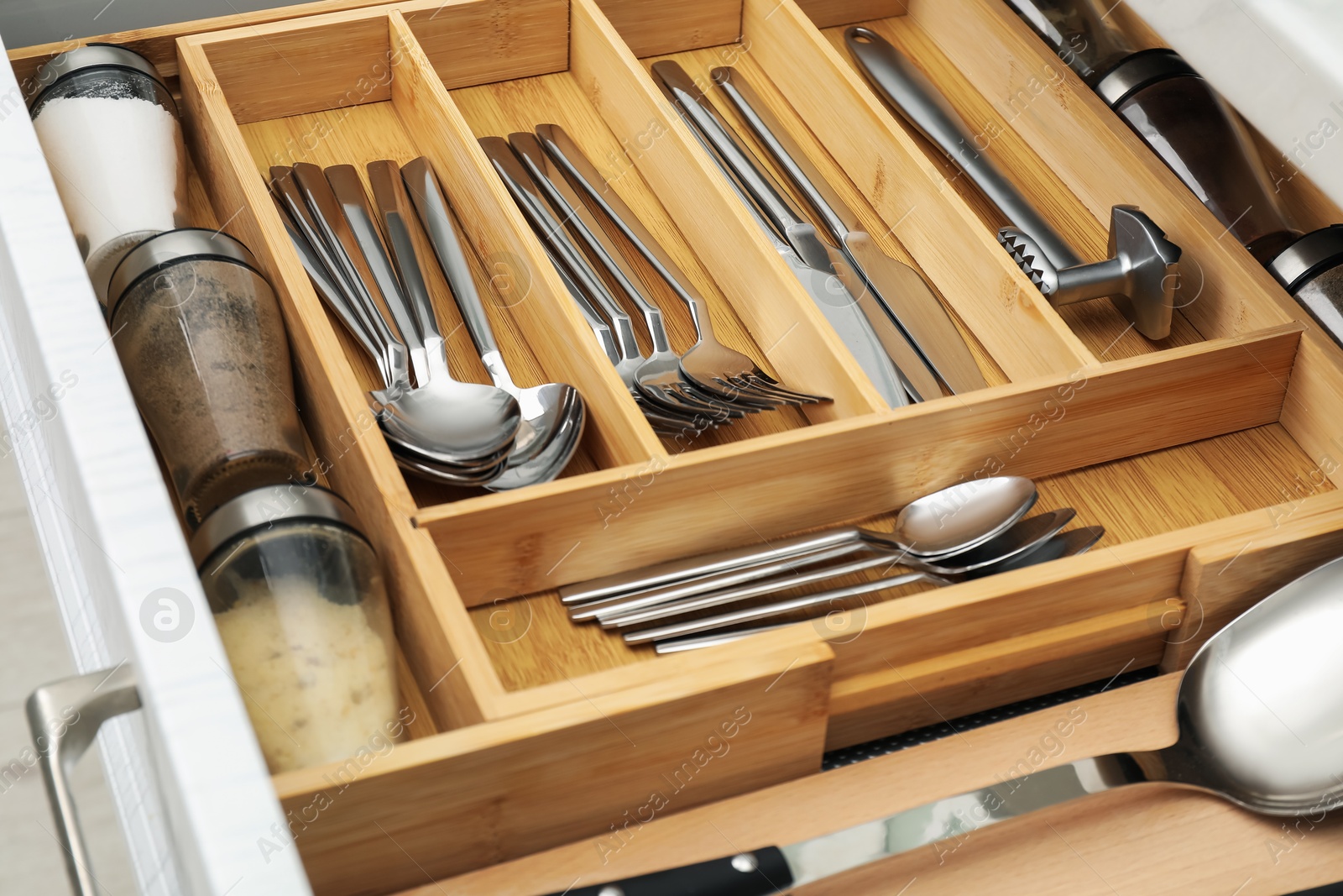 Photo of Box with cutlery in drawer, closeup. Kitchen utensils storage