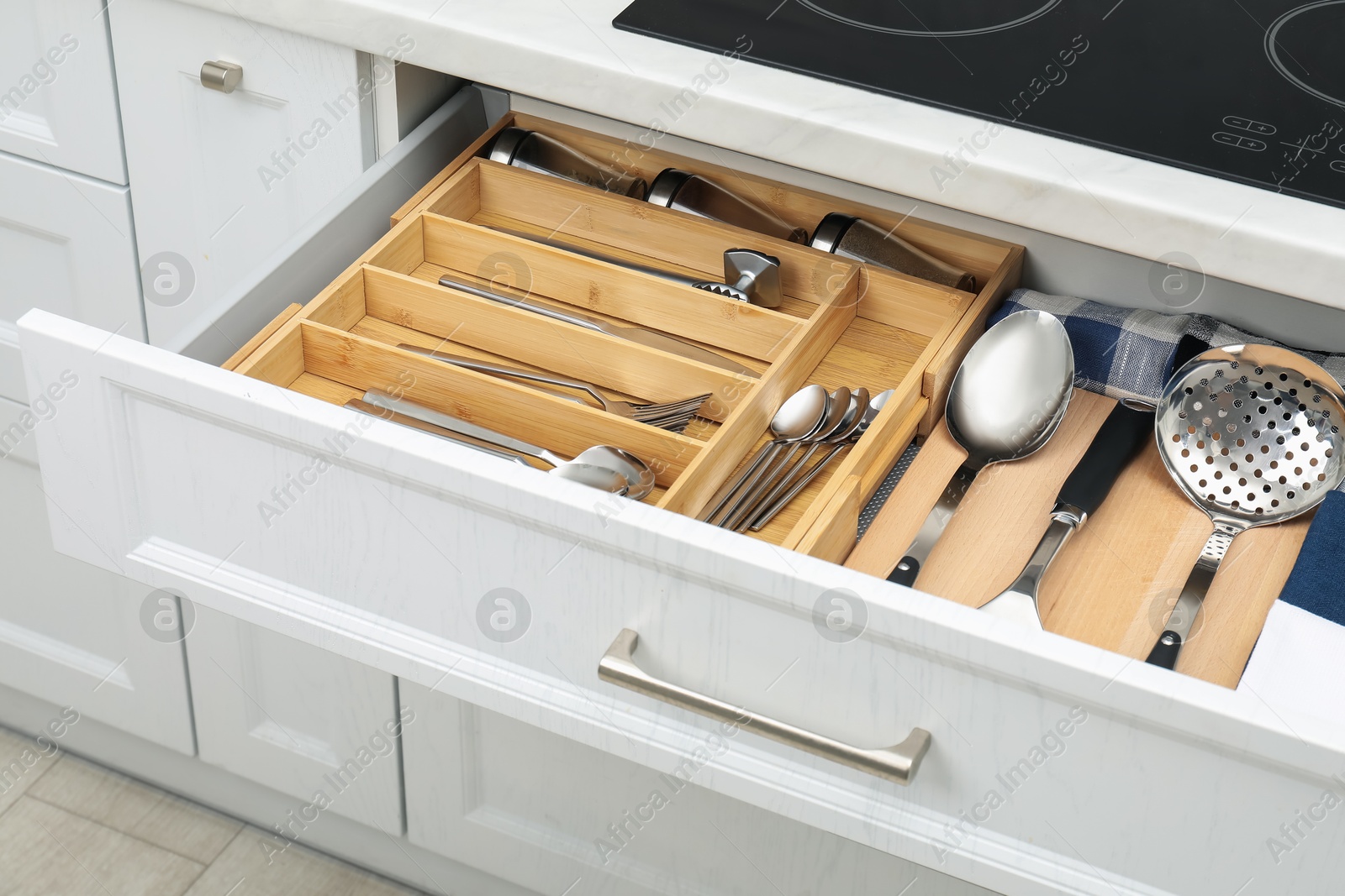 Photo of Box with cutlery in drawer, closeup. Kitchen utensils storage