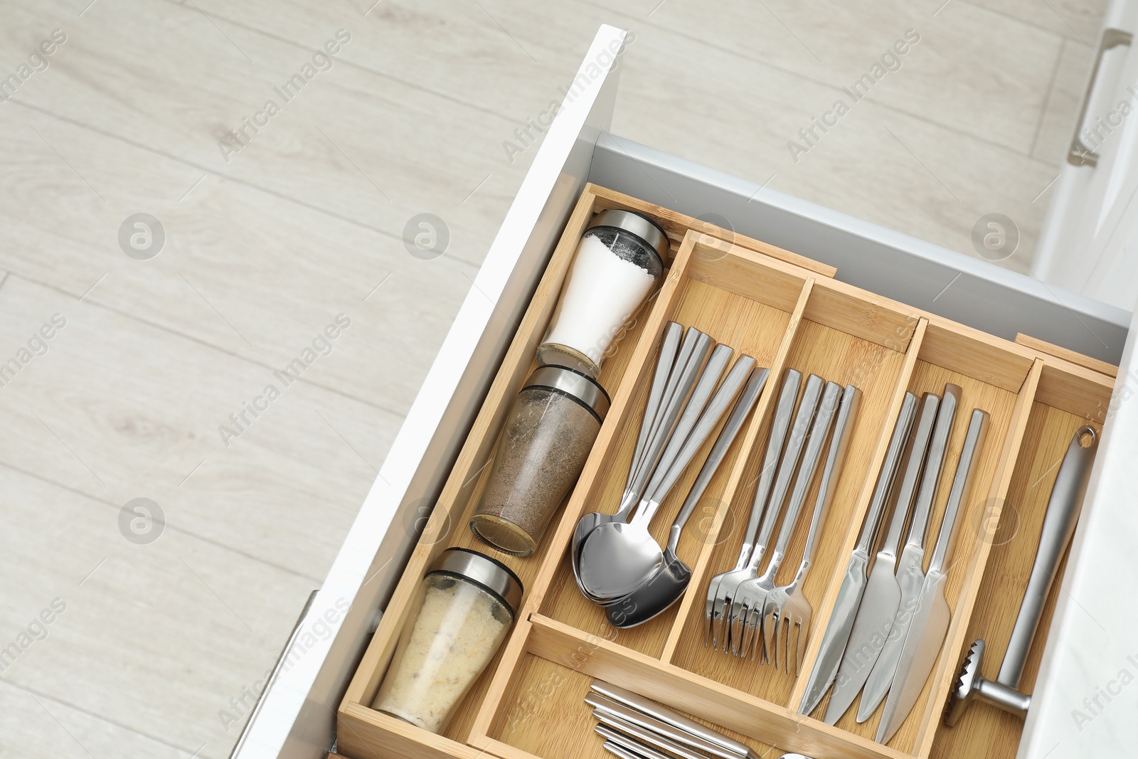 Photo of Box with cutlery in drawer, closeup. Kitchen utensils storage