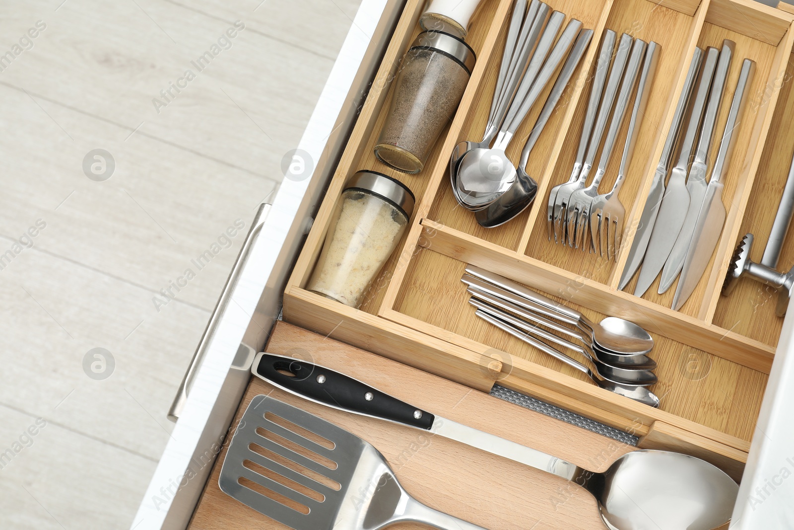 Photo of Box with cutlery in drawer, closeup. Kitchen utensils storage