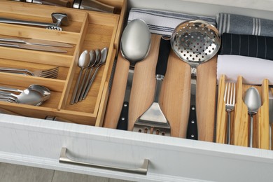 Photo of Box with cutlery in drawer, closeup. Kitchen utensils storage