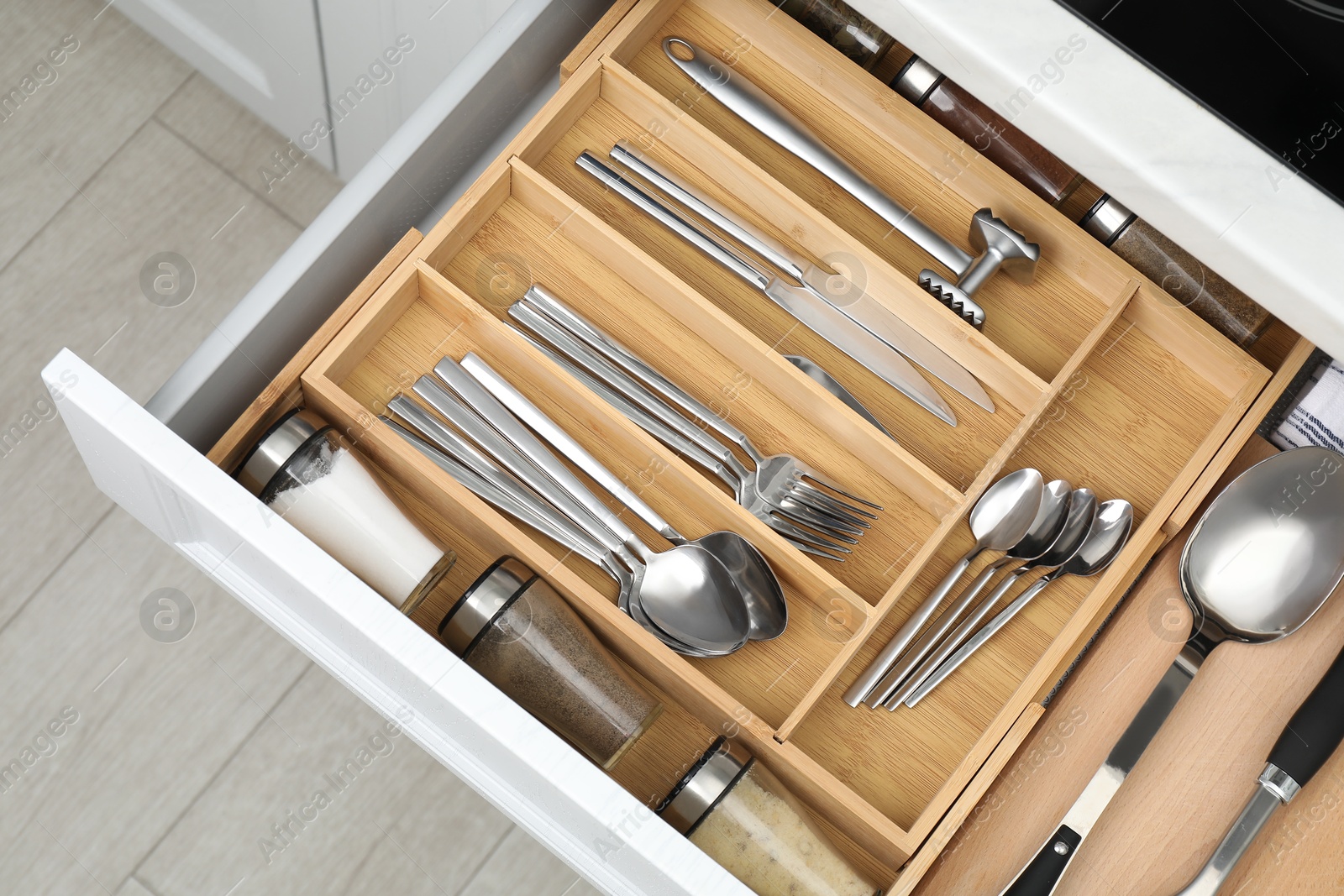 Photo of Box with cutlery in drawer, closeup. Kitchen utensils storage