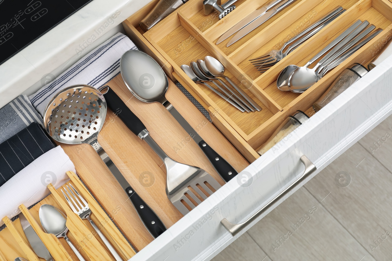 Photo of Box with cutlery in drawer, closeup. Kitchen utensils storage