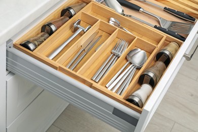 Photo of Box with cutlery in drawer, closeup. Kitchen utensils storage