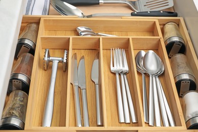 Photo of Box with cutlery in drawer, closeup. Kitchen utensils storage