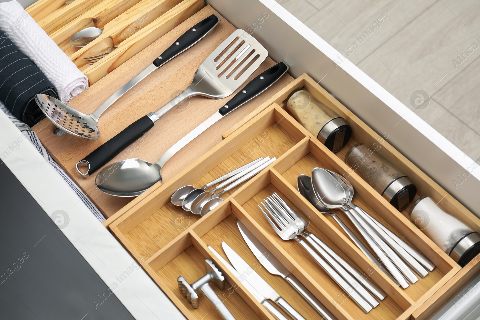 Photo of Box with cutlery in drawer, closeup. Kitchen utensils storage