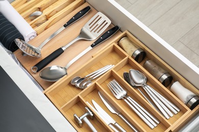 Photo of Box with cutlery in drawer, closeup. Kitchen utensils storage