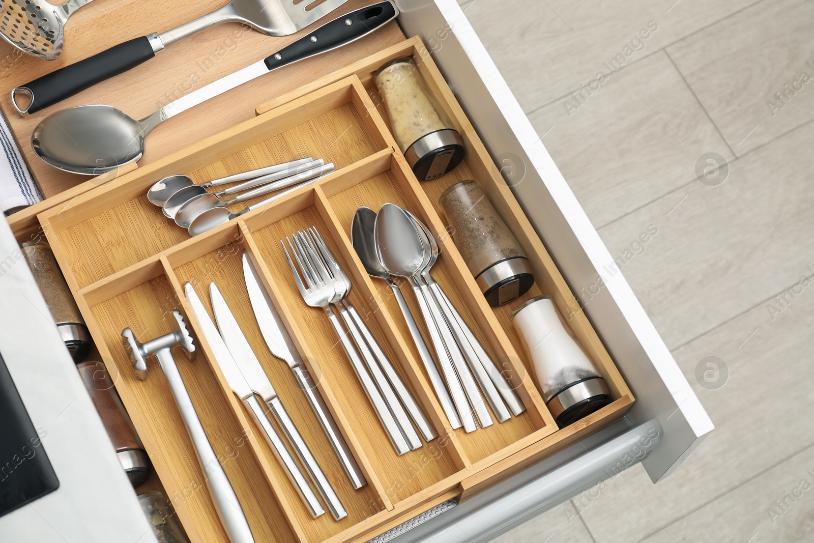 Photo of Box with cutlery in drawer, closeup. Kitchen utensils storage