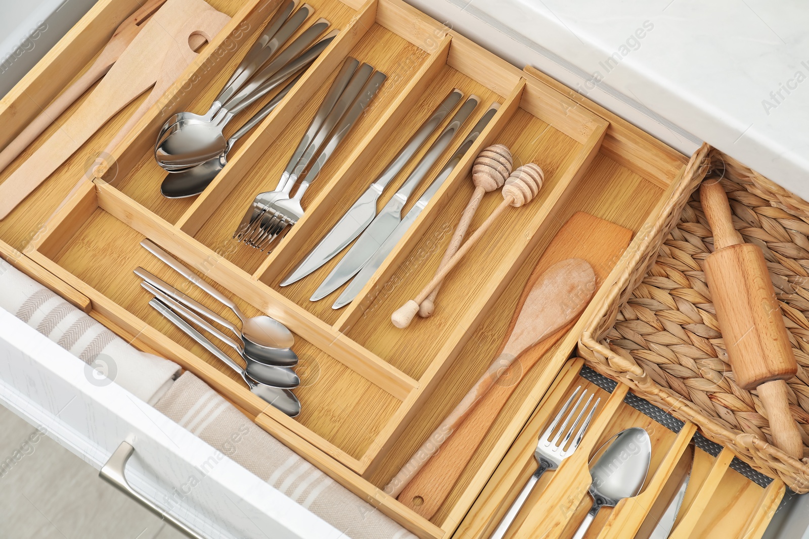 Photo of Box with cutlery in drawer, closeup. Kitchen utensils storage