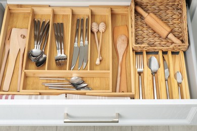 Photo of Box with cutlery in drawer, closeup. Kitchen utensils storage