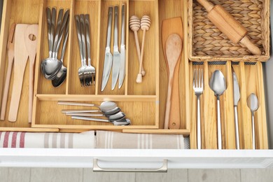 Photo of Box with cutlery in drawer, closeup. Kitchen utensils storage