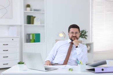 Photo of Portrait of businessman at table in office