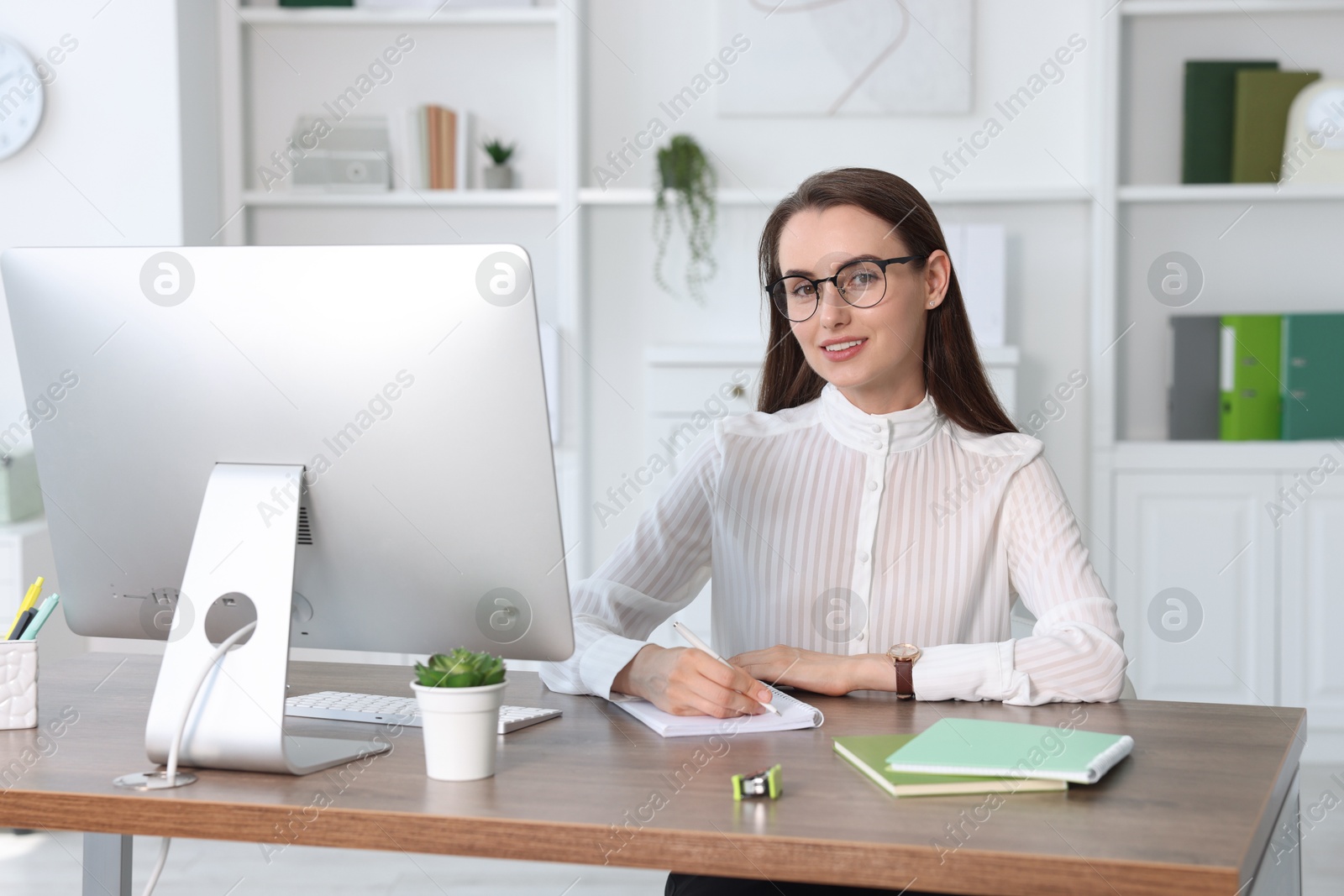 Photo of Portrait of smiling businesswoman at table in office