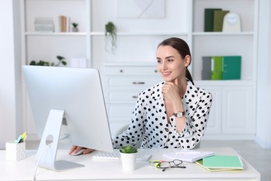 Photo of Smiling businesswoman working at table in office