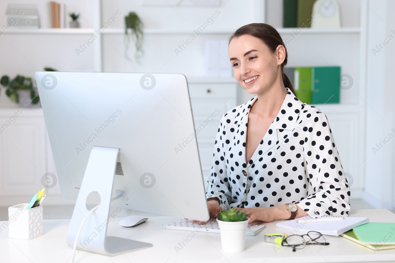 Photo of Smiling businesswoman working at table in office