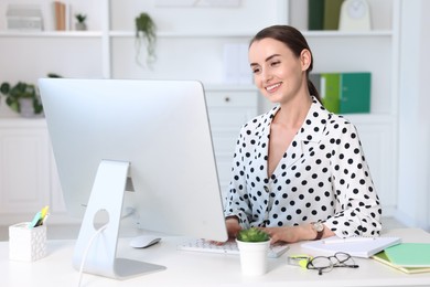 Smiling businesswoman working at table in office