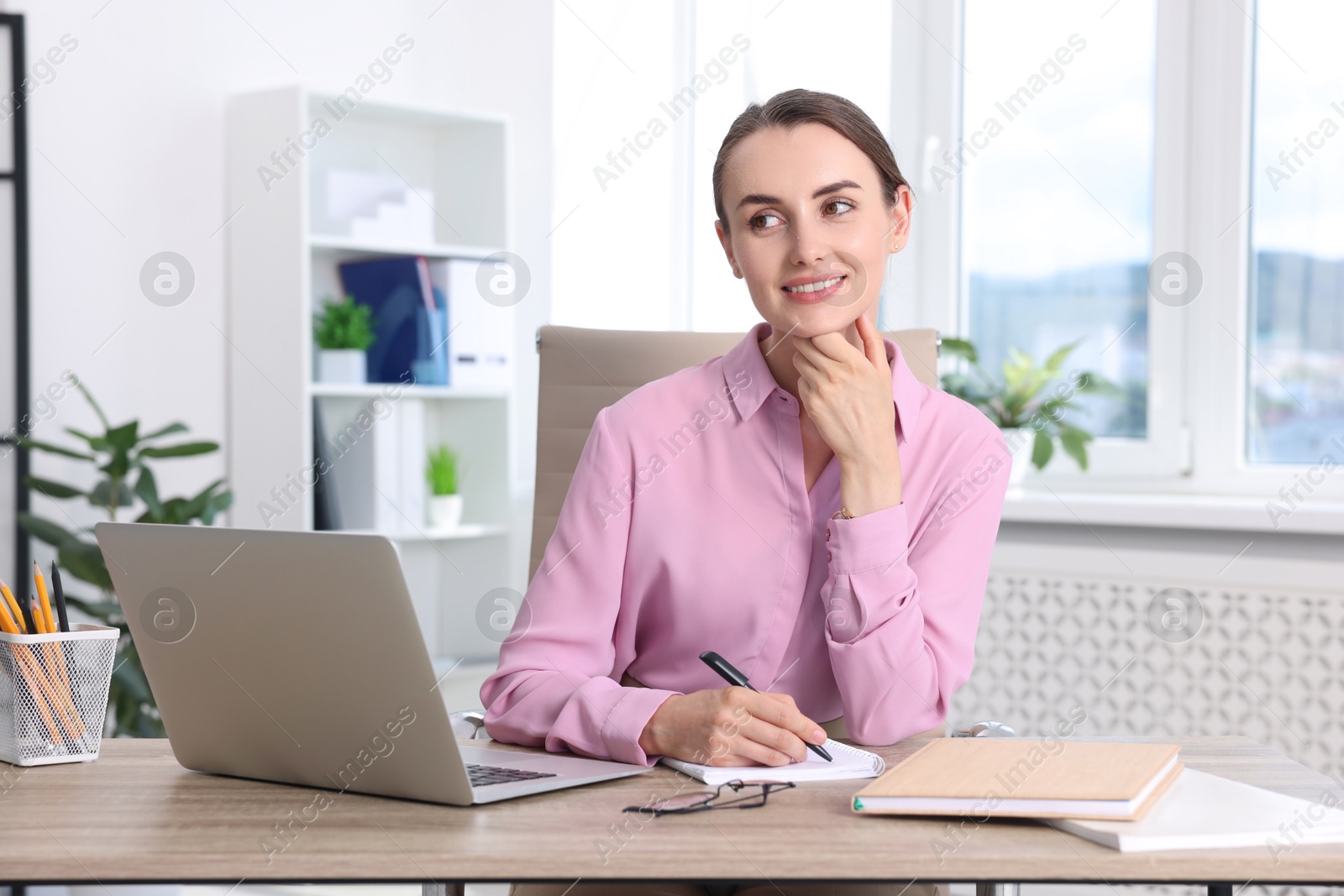 Photo of Portrait of smiling businesswoman at table in office