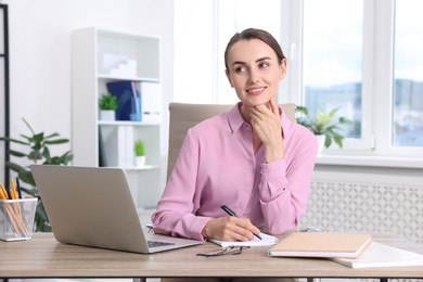 Photo of Portrait of smiling businesswoman at table in office