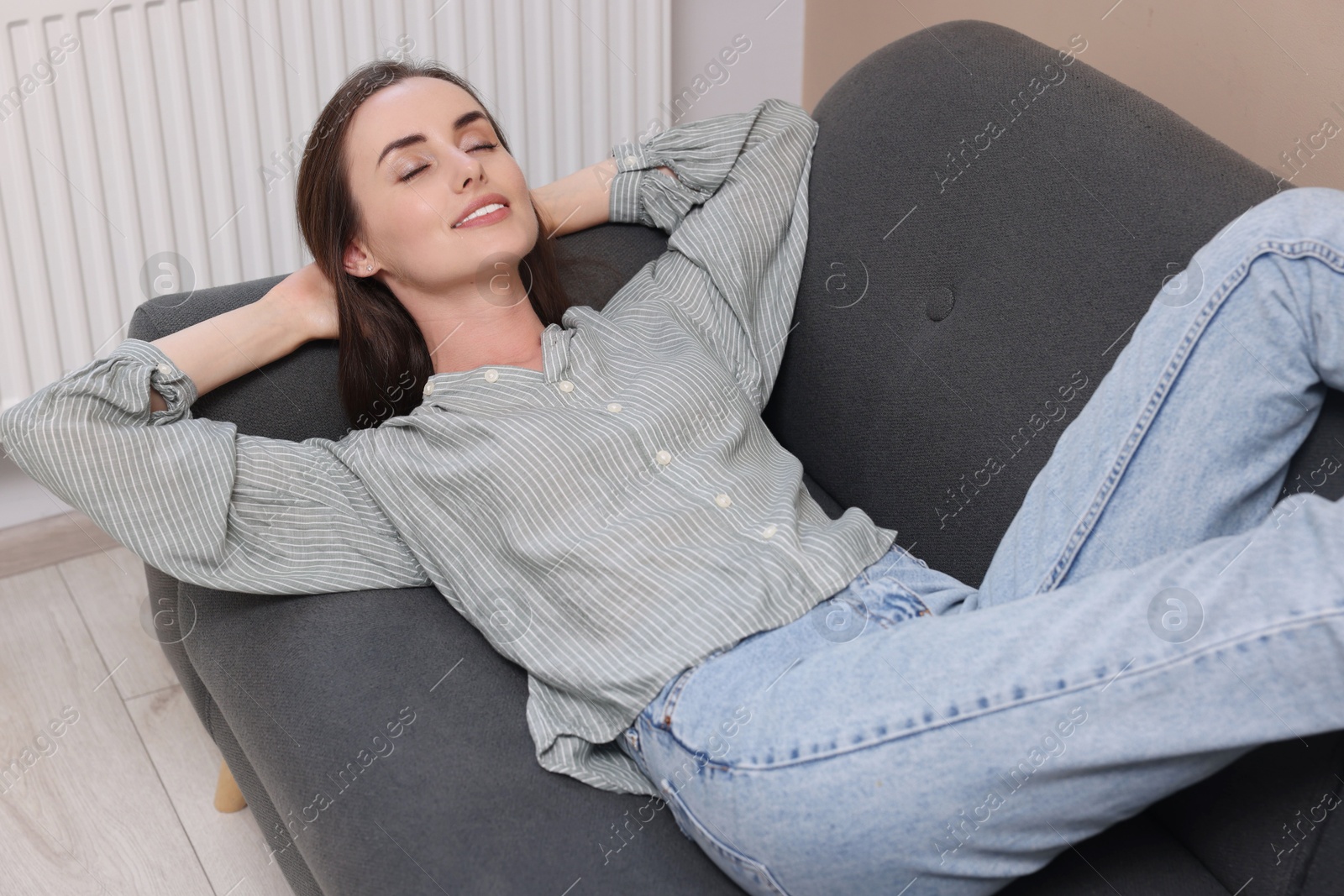 Photo of Smiling woman relaxing on sofa at home