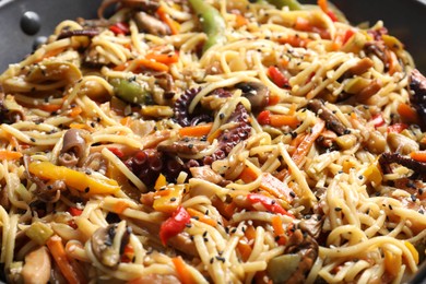 Photo of Stir-fry noodles with sea food and vegetables in wok, closeup