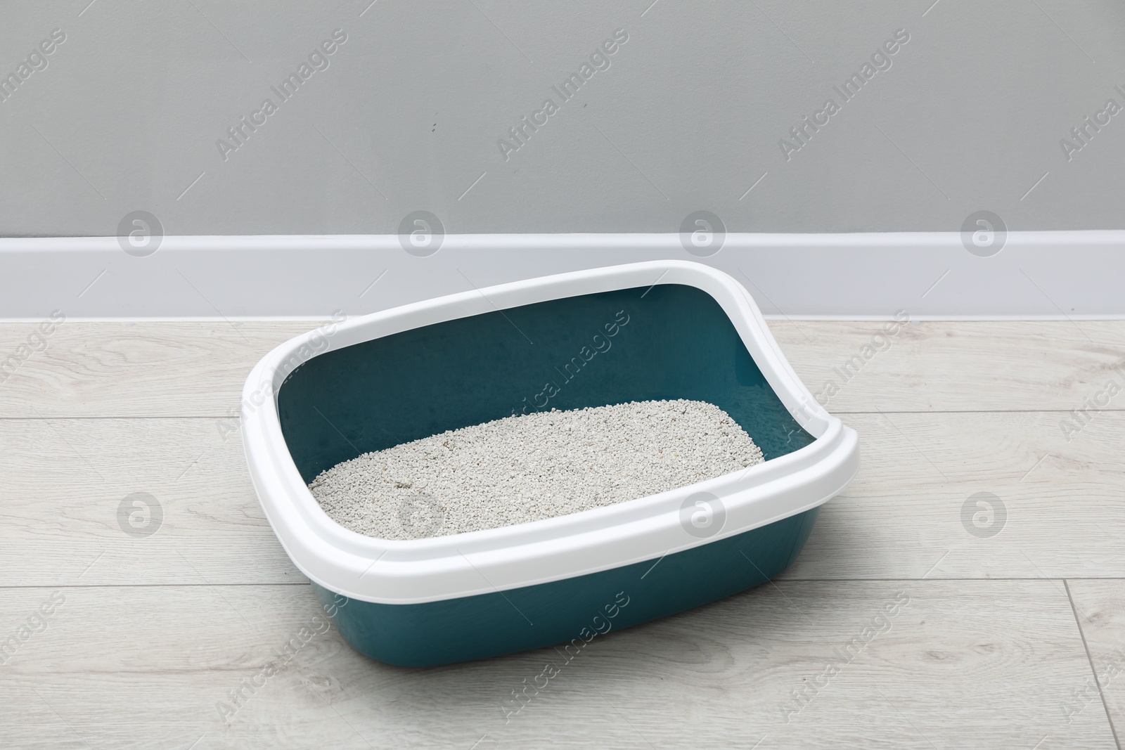 Photo of Cat tray with clumping litter on floor indoors