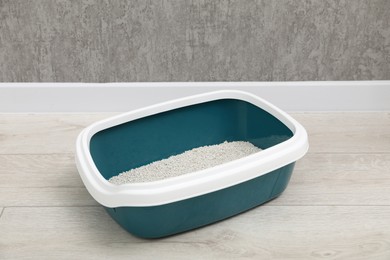 Photo of Cat tray with clumping litter on floor indoors