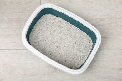 Cat tray with clumping litter on floor indoors, top view