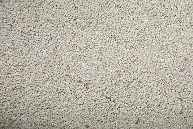 Photo of Clean clay cat litter as background, top view