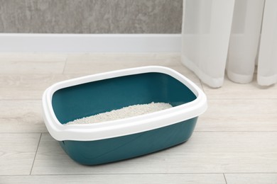 Photo of Cat tray with clumping litter on floor indoors