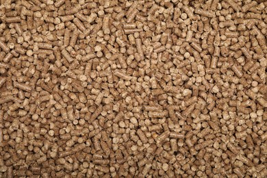 Photo of Wood pellet cat litter as background, top view