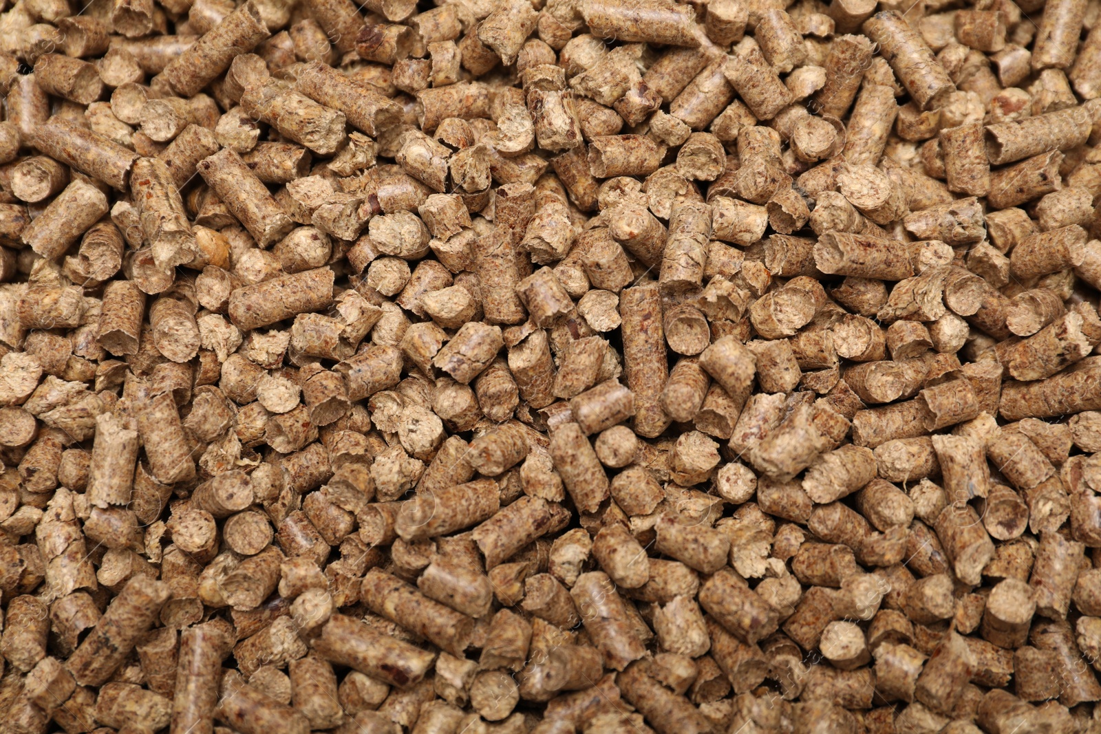 Photo of Wood pellet cat litter as background, top view